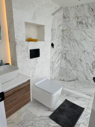 ein weißes Bad mit einem WC und einem Waschbecken in der Unterkunft Icon Cibeles in Mexiko-Stadt