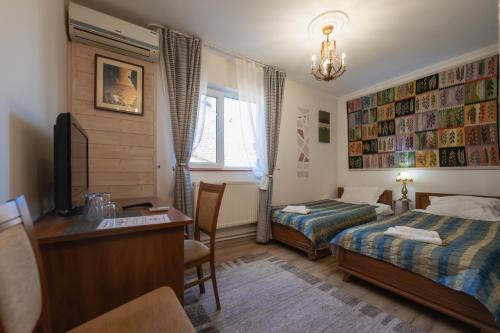 a hotel room with a bed and a desk and a desk at Vila Fortuna - Art O'Clock in Sibiu