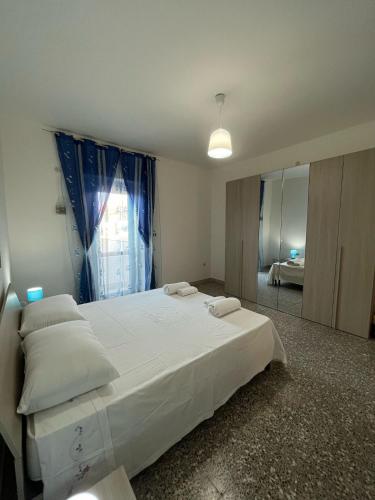 a bedroom with a large white bed and a mirror at Vista Mare in Torre San Gennaro