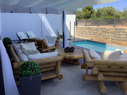 a living room with couches and a swimming pool at WHITE HOUSE IBIZA in Nuestra Señora de Jesus
