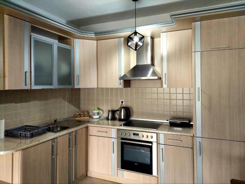 a kitchen with wooden cabinets and a stove top oven at Centro Apartment - Ohrid in Ohrid