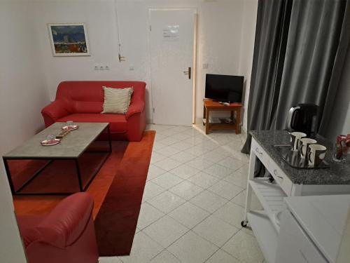 a living room with a red couch and a table at Accommodation Zara in Vukovar