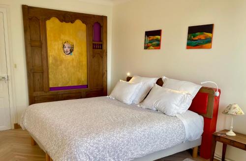 a bedroom with a bed with white pillows at Le Moulin de Bury, Maison de campagne au bord de la rivière à 13 kms au Sud de Rennes in Chavagne