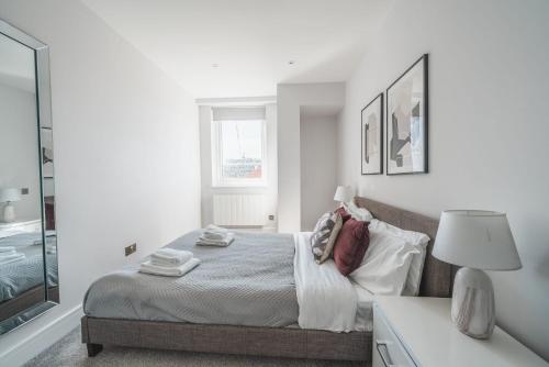 a white bedroom with a bed and a window at Modern 1 Bedroom Apartment in Central Eastleigh in Eastleigh