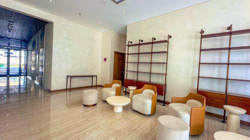 una sala de espera con sillas blancas y una mesa en Aaderi Homes, en Dubái