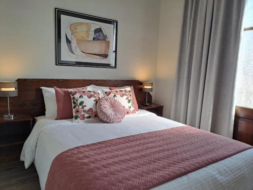 a bedroom with a large bed with pillows at Hotel Casa Aure in Santiago