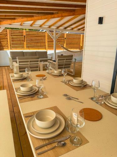 a table with plates and wine glasses on it at Kay Alice - Beachfront Villa in Le Carbet