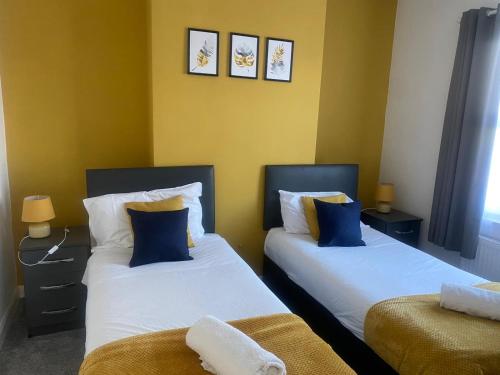 two beds sitting next to each other in a room at Spacious 3BR House Near Southend Pier in Southend-on-Sea