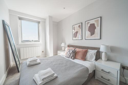 a white bedroom with a bed and a window at Central Eastleigh 1 Bedroom Apartment in Eastleigh