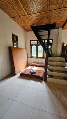 a bedroom with a bed in a room with stairs at White house Sumatra Bukit Lawang in Timbanglawang