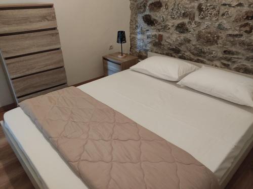 Ce lit se trouve dans une chambre dotée d'un mur en pierre. dans l'établissement Light and sea 2, à Kavala