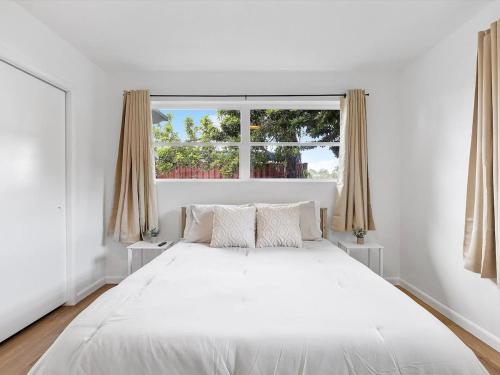 uma cama branca num quarto branco com uma janela em 3BR Newly Renovated In Miami 15 Min To Beach em Miami