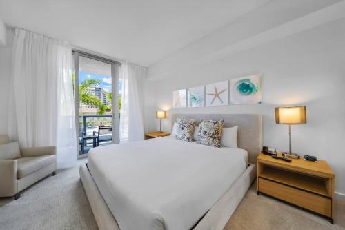 um quarto branco com uma cama e um sofá em Beachwalk -1 Bedroom With Kitchen Pool And Gym em Hallandale Beach