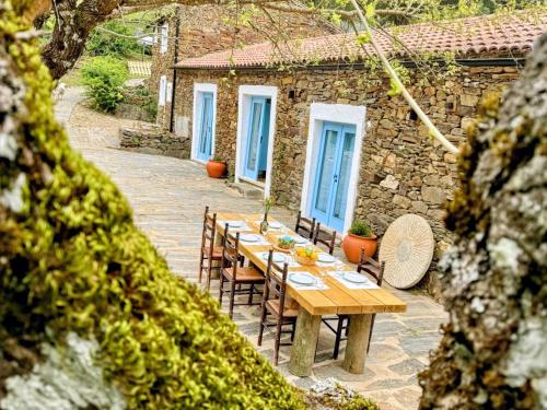 a wooden table and chairs in front of a building at Moinho do Maneio in Penamacor