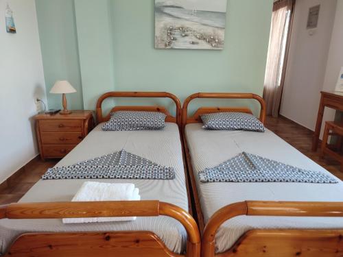 two beds sitting next to each other in a bedroom at ANATOLI ROOMS SERIFOs in Serifos Chora