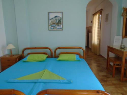 a bedroom with a blue table with two chairs at ANATOLI ROOMS SERIFOs in Serifos Chora