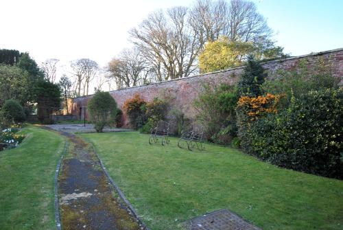 a garden with two bikes parked next to a brick wall at Kirkmay House Apartment in Crail