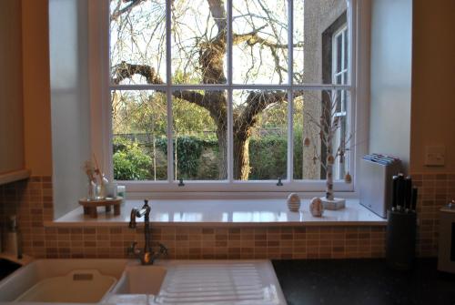 a bathroom with a large window and a sink at Kirkmay House Apartment in Crail