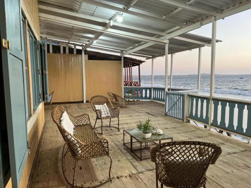 eine Veranda mit Stühlen, einem Tisch und Meerblick in der Unterkunft Casa Esmeralda in Colán