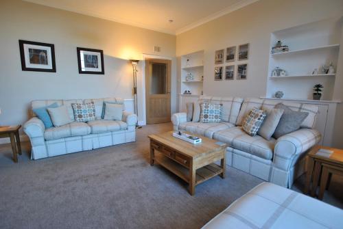 a living room with two couches and a coffee table at Kirkmay House Apartment in Crail