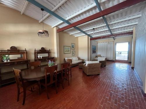 ein Wohnzimmer mit einem Tisch, Stühlen und einem Sofa in der Unterkunft Casa Esmeralda in Colán