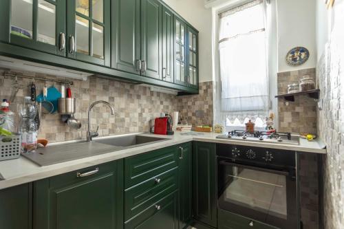 a kitchen with green cabinets and a sink at Little's Venaria in Venaria Reale