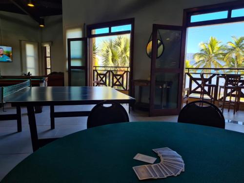 a dining room with two tables and a view of the ocean at Ilha Flat Hotel in Ilhabela