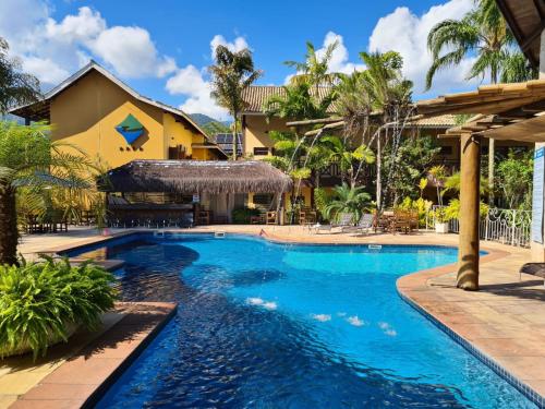 a swimming pool at a resort with a resort at Ilha Flat Hotel in Ilhabela