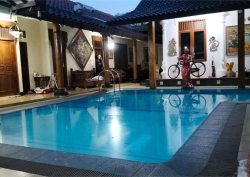 uma grande piscina com água azul num hotel em Sekar Wangi Homestay em Sleman