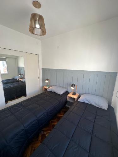 1 dormitorio con 2 camas y espejo en Experiencia unica en el casco historico bonaerense en Buenos Aires