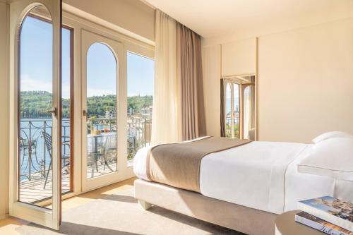 a bedroom with a large bed and a balcony at Bellerive Lifestyle Hotel in Salò