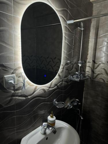 La salle de bains est pourvue d'un lavabo et d'un miroir. dans l'établissement Guesthouse Elia, à Kazbegi