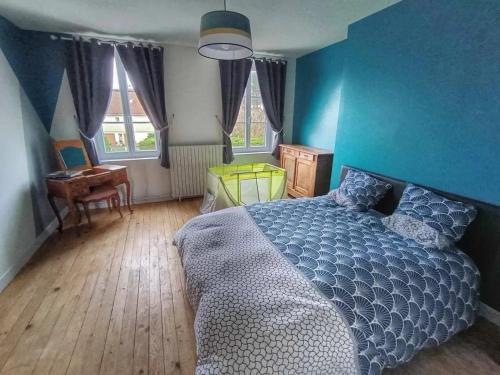 a bedroom with blue walls and a bed and a desk at Villa de 4 chambres avec piscine privee sauna et jardin clos a La Poterie Cap d'Antifer in La Poterie-Cap-dʼAntifer