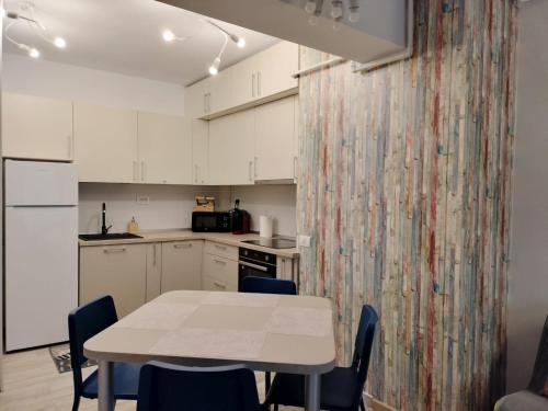 a kitchen with white cabinets and a table and chairs at M Suites in Cluj-Napoca