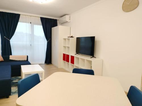 a living room with a white table and blue chairs at M Suites in Cluj-Napoca