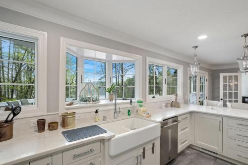 a kitchen with white counters and windows and a sink at Bella Di Lago in Wilkesboro