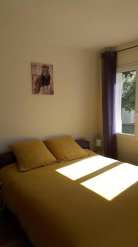 une chambre avec un grand lit avec une fenêtre dans l'établissement Chez Nathalie, au Luc