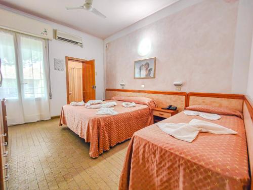 Hotel Rosa tesisinde bir odada yatak veya yataklar