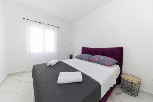 um quarto com uma cama com duas toalhas em Roko house - Right next to the sea em Petrcane