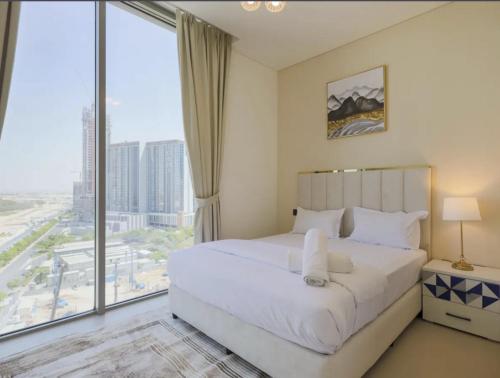 - une chambre avec un grand lit et une grande fenêtre dans l'établissement Dubai World Central Budget Apartments, à Dubaï