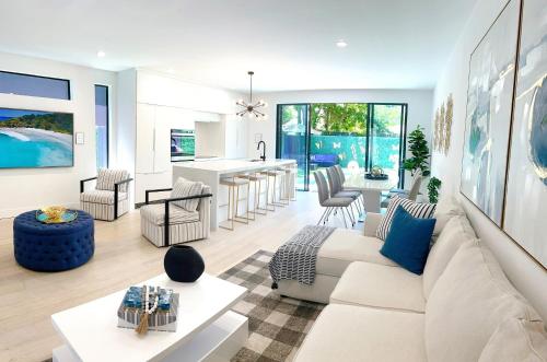 a living room with a white couch and a kitchen at Luxury Villa in Design District (heated saltwater pool) in Miami