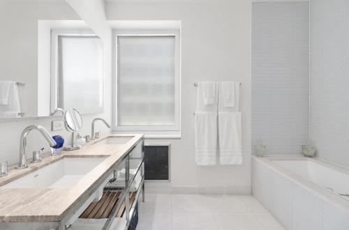 Baño blanco con 2 lavabos y bañera en Luxury 4 Bedroom Apartment near Times Square NYC en Nueva York