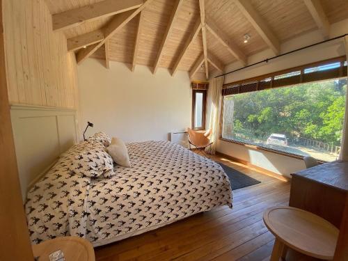 um quarto com uma cama e uma grande janela em Amplia casa familiar en Cachagua em Zapallar