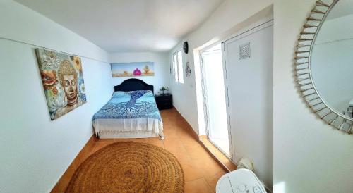 1 dormitorio con 1 cama en una habitación con espejo en Atico en Puerto Rey Urbanizacion La Aldea, en Vera
