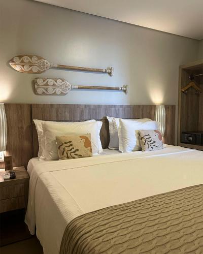a bedroom with a large bed with white sheets and pillows at Porto das Dunas Boutique Praia Hotel in Aquiraz