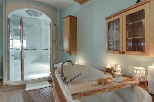 La salle de bains est pourvue d'une baignoire et d'une douche avec des bougies. dans l'établissement Chalet Grand-père Tortue, à Saint-David-de-Falardeau