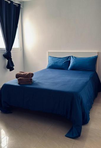 a blue bed with blue sheets and a window at Lighthouse in Puerto del Rosario