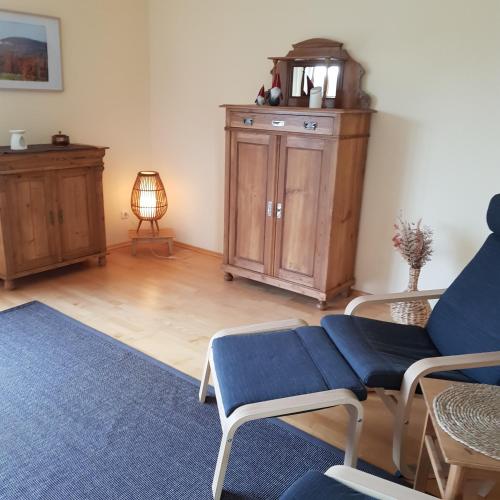 a living room with a blue couch and a table at Jurasonne in Gräfenberg