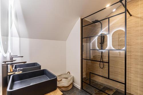 La salle de bains est pourvue d'un lavabo noir et d'une douche. dans l'établissement 5 SUQ - Splendide appartement rénové proche Palais et plages, à Cannes