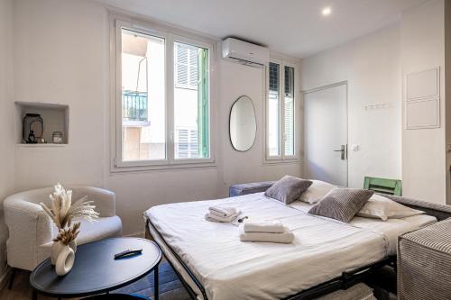 une chambre avec un lit, une table et une chaise dans l'établissement 5 SUQ - Splendide appartement rénové proche Palais et plages, à Cannes